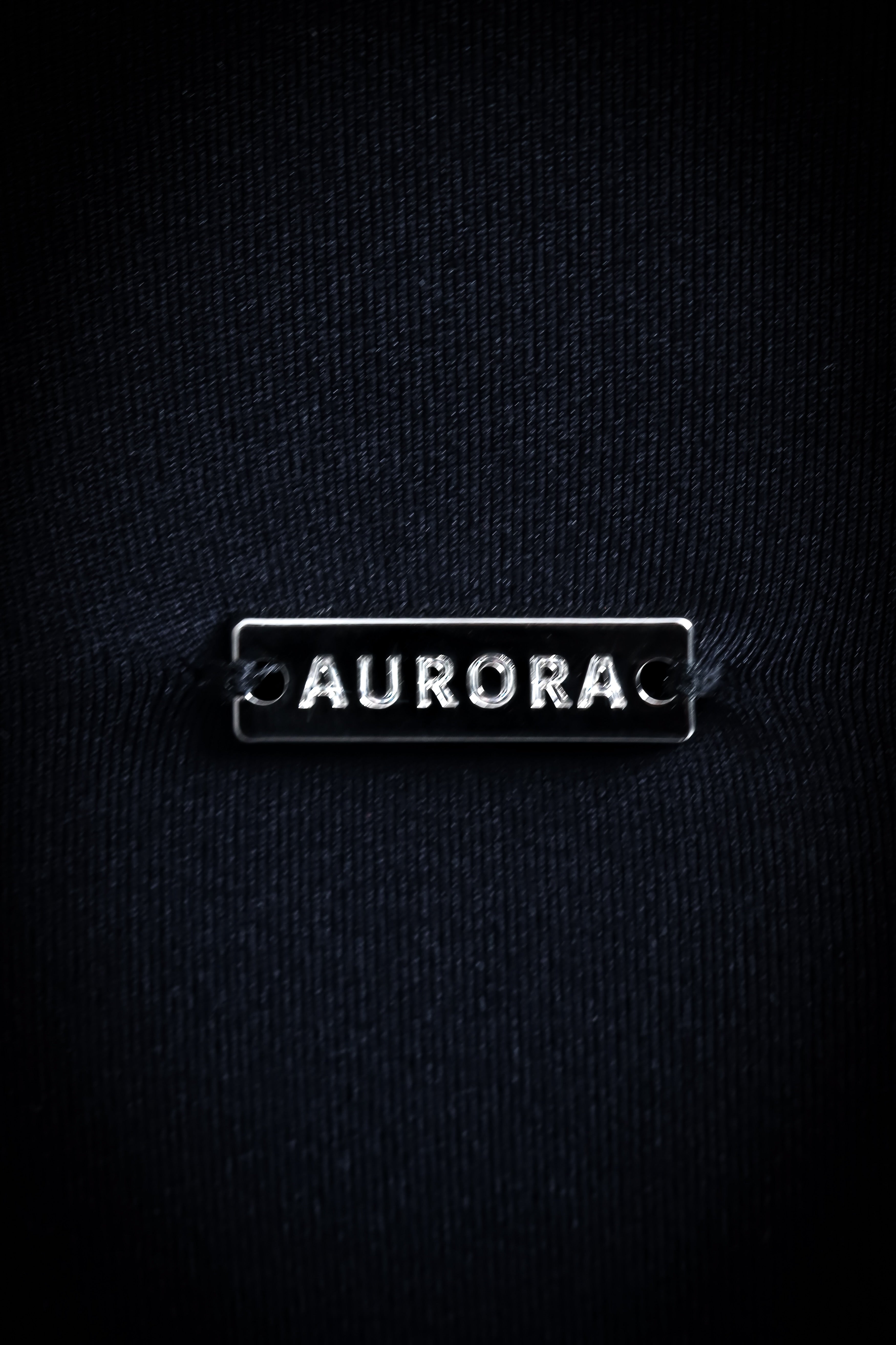 Aurora Sense Bra sort med dyb V-ryg for elegance og et diskret metallogo, designet til både komfort og støtte under træning.