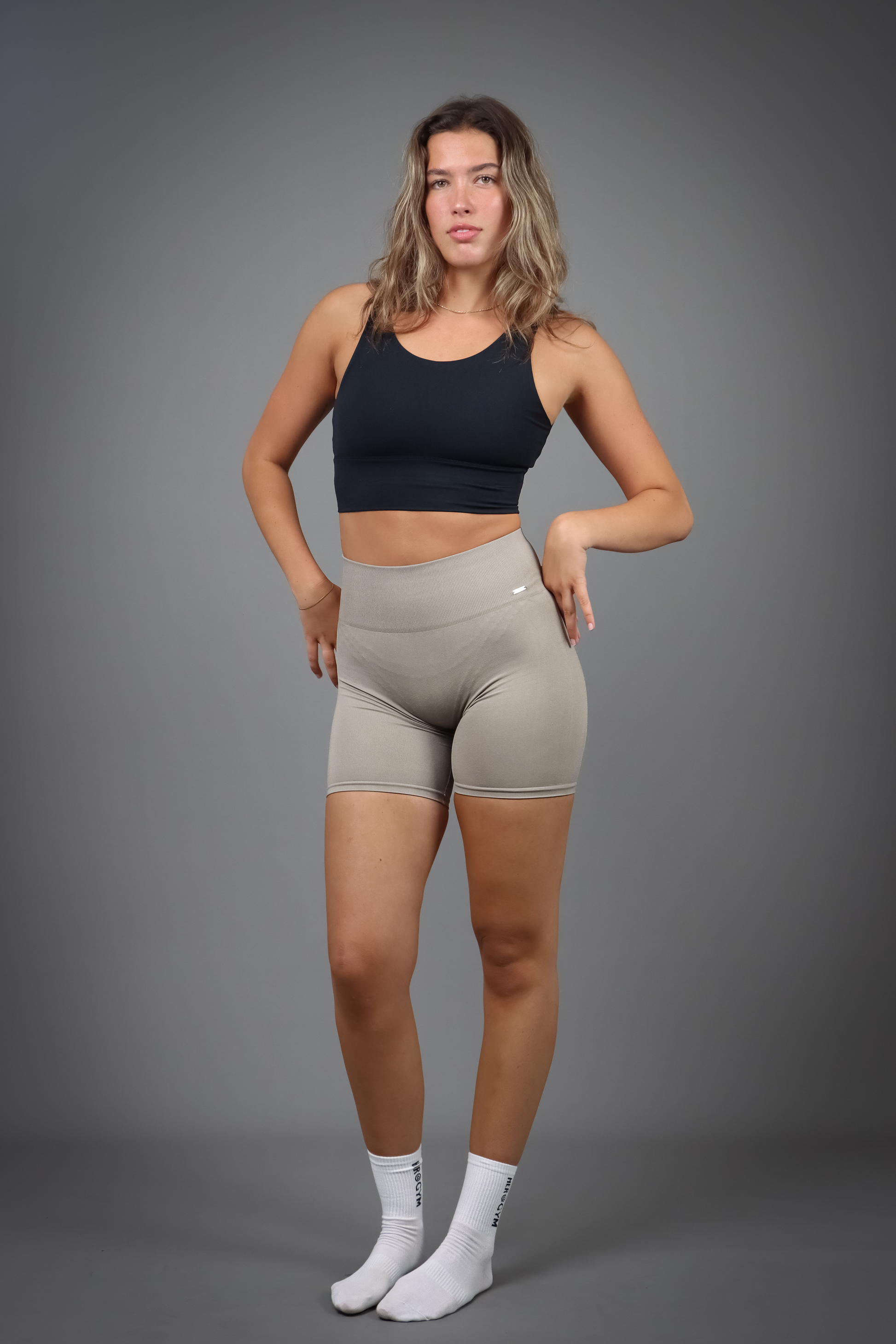 Aurora Sense Shorts Taupe med seamless teknologi og høj talje for komfort og en flatterende pasform, med et diskret metallogo for et elegant og minimalistisk look.