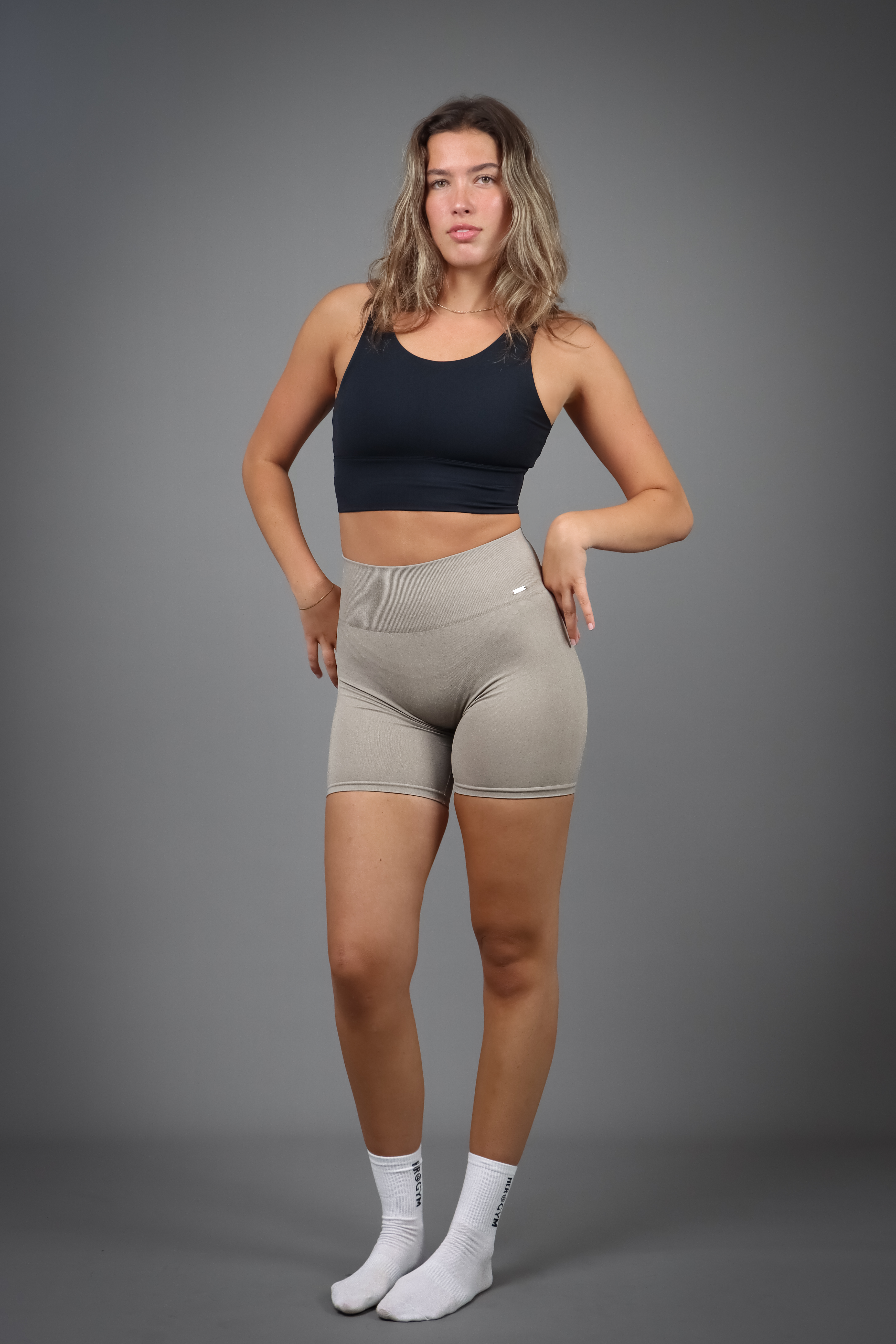 Aurora Sense Shorts Taupe med seamless teknologi og høj talje for komfort og en flatterende pasform, med et diskret metallogo for et elegant og minimalistisk look.